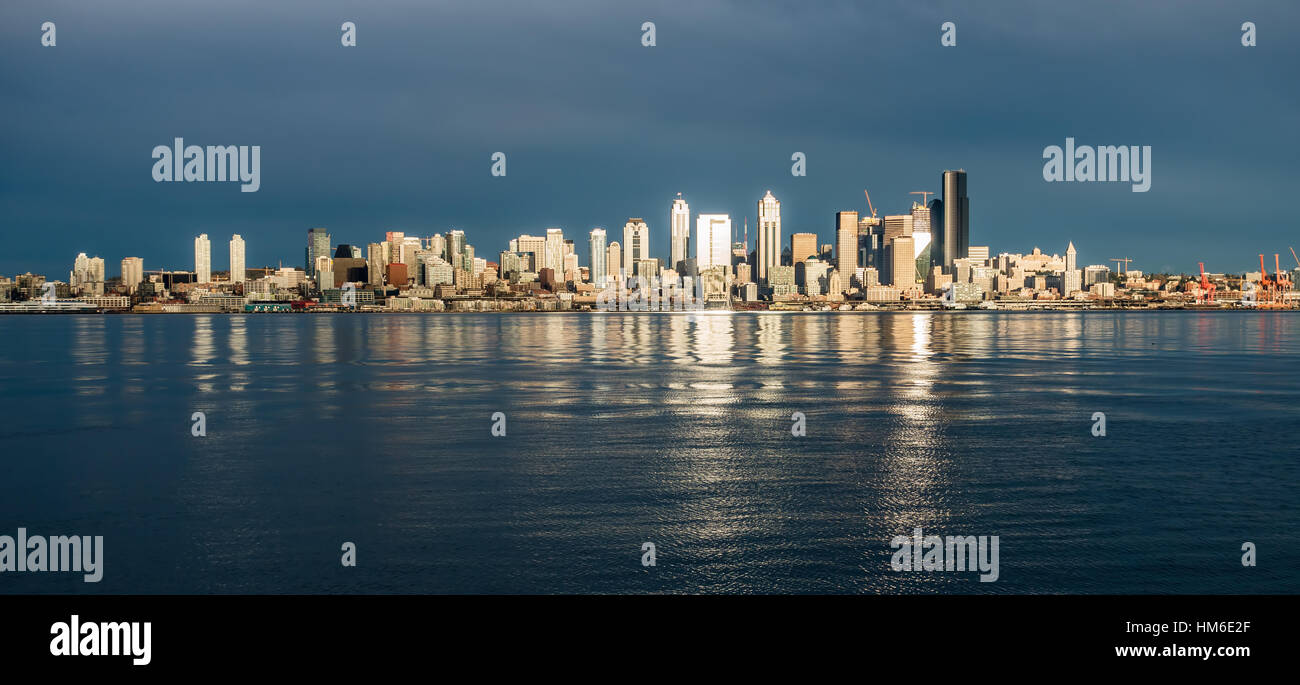 Come il sole tramonta edifici della skyline di Seattle sono riflesse nella Baia di Elliott. Foto Stock