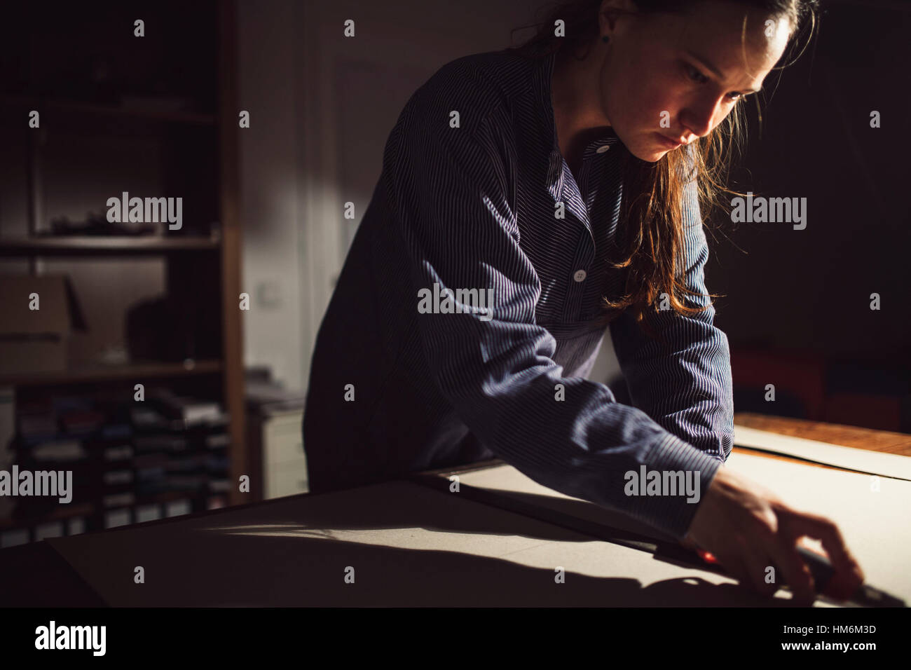 Frau zeichnet Pappe un, Schritt eins beim Buchbinden, Umschlagsgestaltung Foto Stock