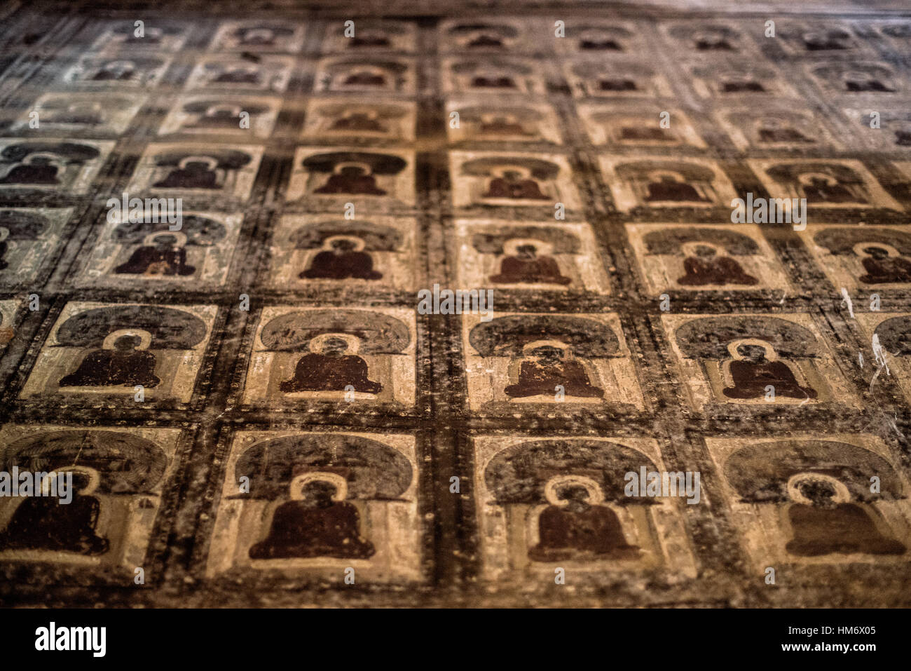 Affreschi del Tempio di Lemyethna Bagan Myanmar // BAGAN, Myanmar — intricati affreschi composti da piccole illustrazioni simili a piastrelle che creano motivi geometrici adornano le pareti interne e i soffitti del Tempio di Lemyethna (noto anche come Pagoda di Lemyethna), un tempio buddista costruito nel 1223 d.C. durante il regno di re Htilominlo. Costruito da Anandathura, un ministro della corte reale, il tempio presenta una base quadrata con elaborate decorazioni in stucco e quattro stanze del santuario che ospitano statue di Buddha rivolte verso le direzioni cardinali. Il programma decorativo del tempio originariamente includeva estesi dipinti murali depic Foto Stock