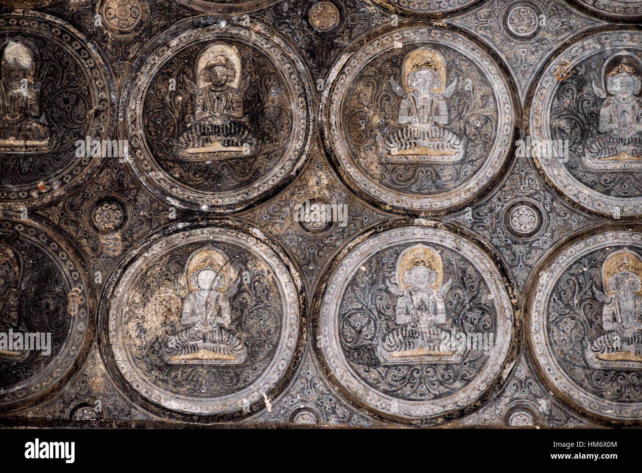 Affreschi del Tempio di Lemyethna Bagan Myanmar // BAGAN, Myanmar — intricati affreschi composti da piccole illustrazioni simili a piastrelle che creano motivi geometrici adornano le pareti interne e i soffitti del Tempio di Lemyethna (noto anche come Pagoda di Lemyethna), un tempio buddista costruito nel 1223 d.C. durante il regno di re Htilominlo. Costruito da Anandathura, un ministro della corte reale, il tempio presenta una base quadrata con elaborate decorazioni in stucco e quattro stanze del santuario che ospitano statue di Buddha rivolte verso le direzioni cardinali. Il programma decorativo del tempio originariamente includeva estesi dipinti murali depic Foto Stock