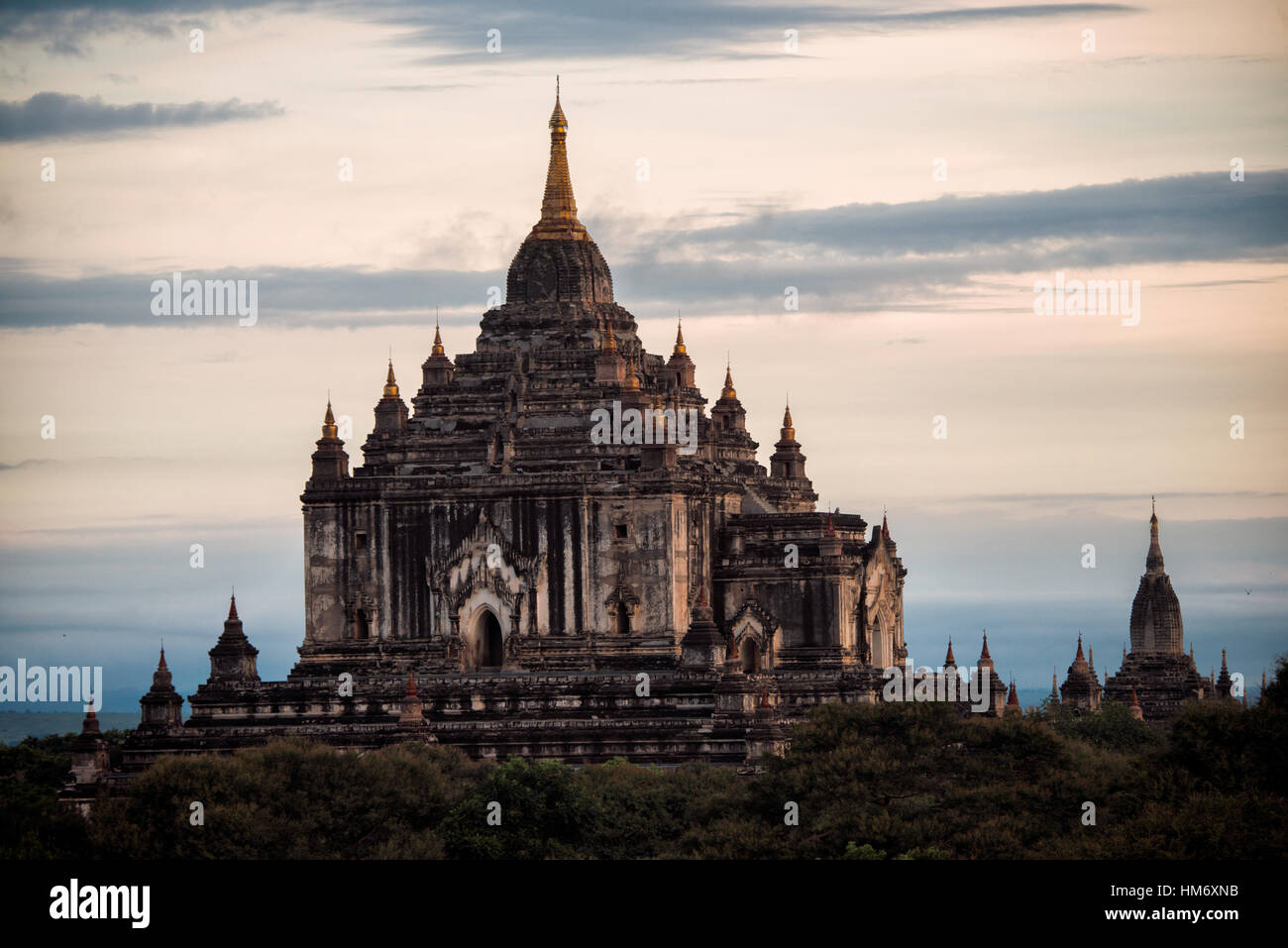 Tempio di Thatbyinnyu Bagan Myanmar // BAGAN, Myanmar - Tempio di Thatbyinnyu, costruito durante il regno di re Alaungsithu tra il 1144 e il 1150-51, è il tempio più alto della zona archeologica di Bagan, a 66 metri (217 piedi). Il tempio segnò una significativa transizione architettonica dagli stili influenzati da Mon al design distintamente di Bamar, diventando il primo tempio a due piani costruito a Bagan. La sua struttura innovativa ha stabilito un modello che ha influenzato i successivi templi principali tra cui Sulamani, Gawdawpalin e Htilominlo. Il tempio ha subito gravi danni in terremoti nel 1975 e nel 2016, Foto Stock