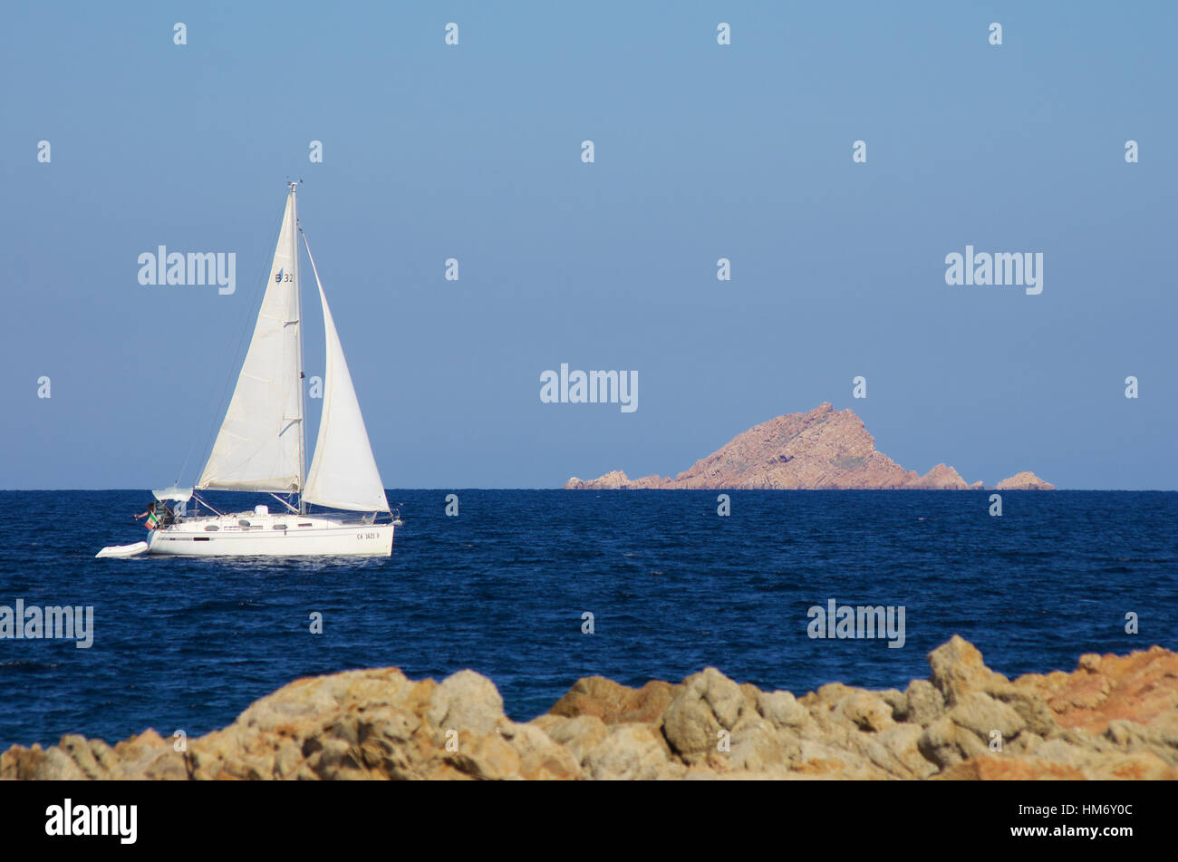 Barca a vela bianca lungo la costa di granito della Sardegna, nei pressi di San Teodoro Foto Stock