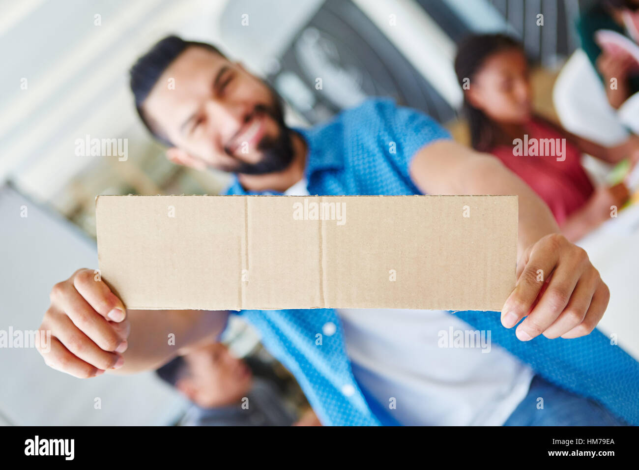 Giovani start-up imprenditore tenendo premuto segno di vuoto in laboratorio creativo Foto Stock