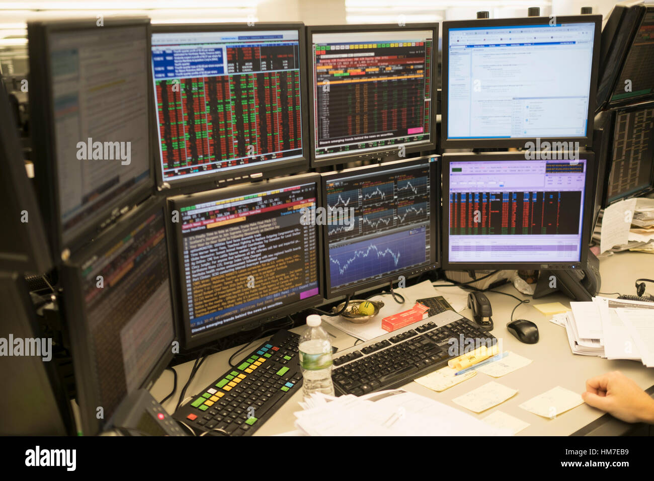 Giovane uomo che lavora sul gruppo di monitor per computer Foto Stock