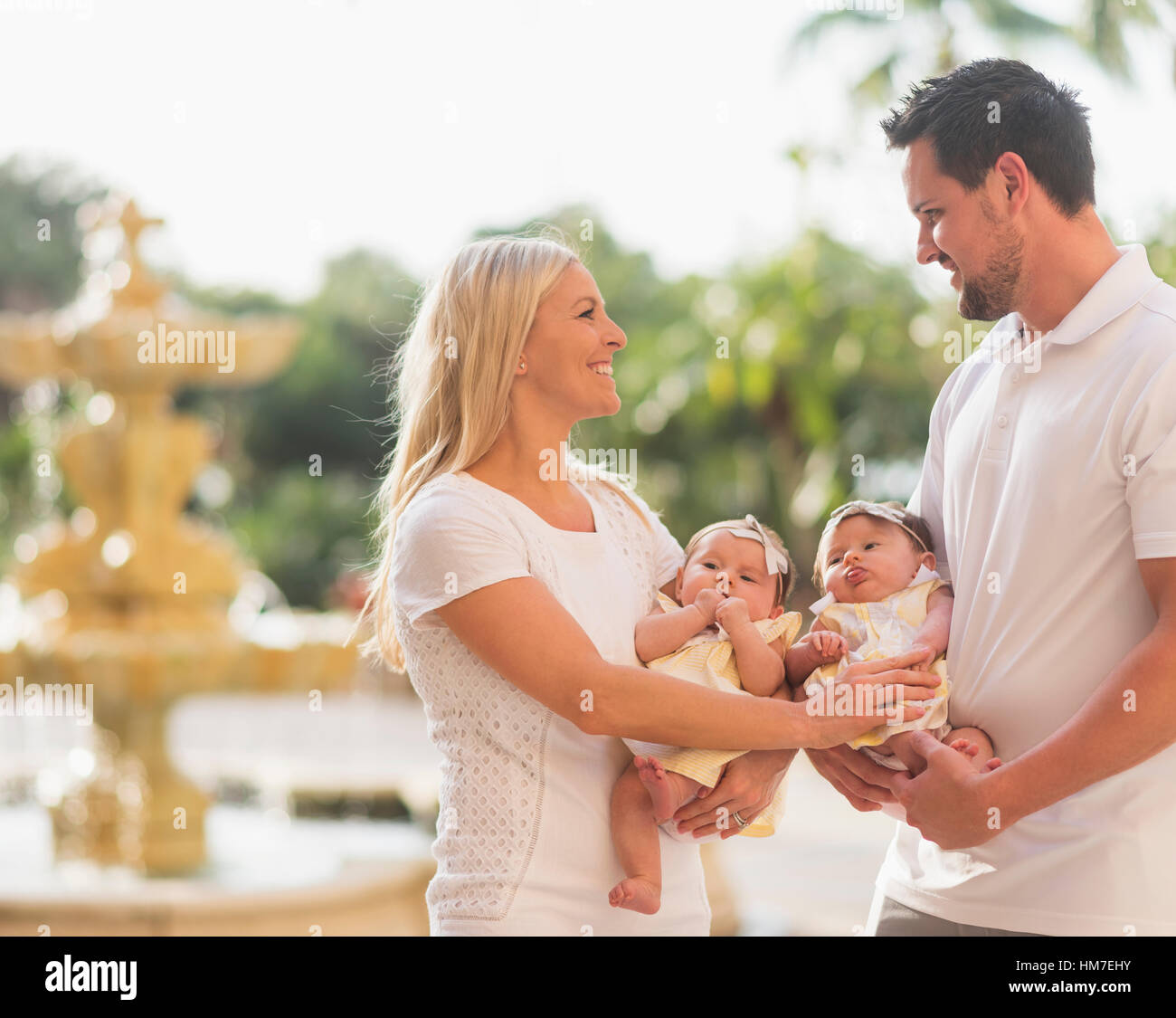 La famiglia felice con due ragazze baby (2-5 mesi) in posizione di parcheggio Foto Stock