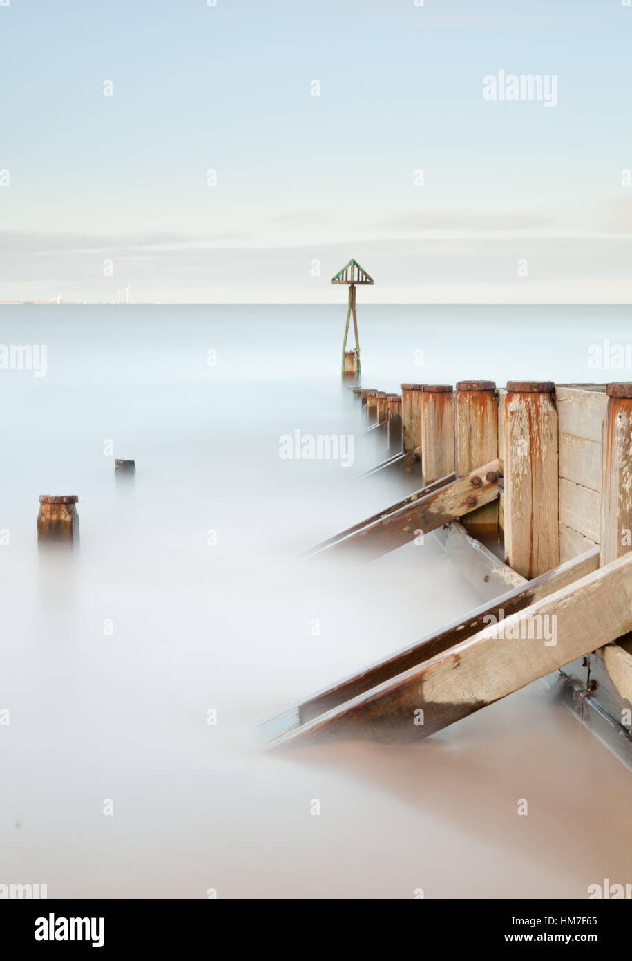 Il triangolo verde e groyne in legno all'ingresso Seaton Sluice porto sulla costa di Northumberland, una lunga esposizione Foto Stock