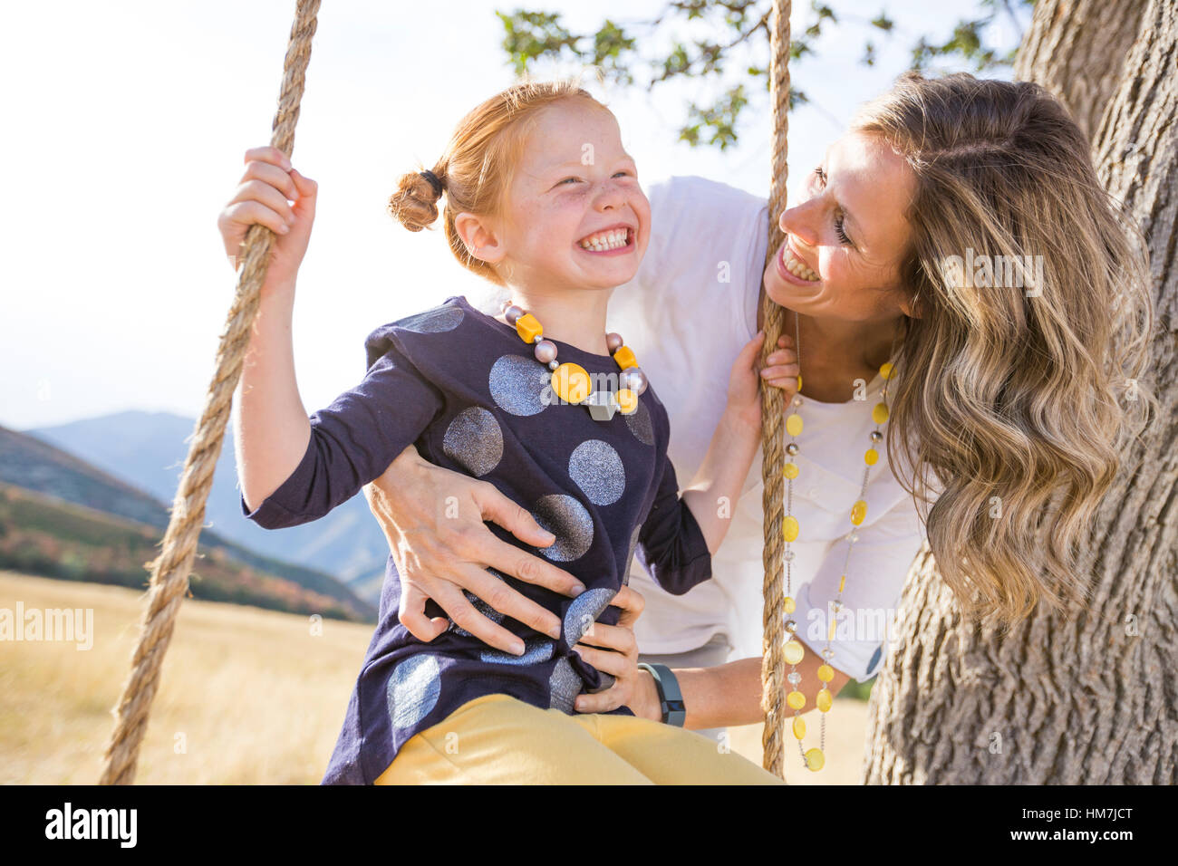 Madre con la ragazza (4-5) seduto su swing Foto Stock