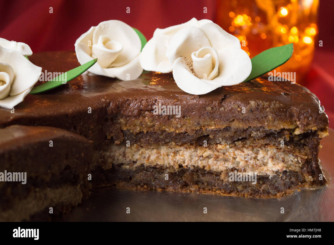 Fette di torta al cioccolato decorata con prodotti commestibili rose bianche Foto Stock