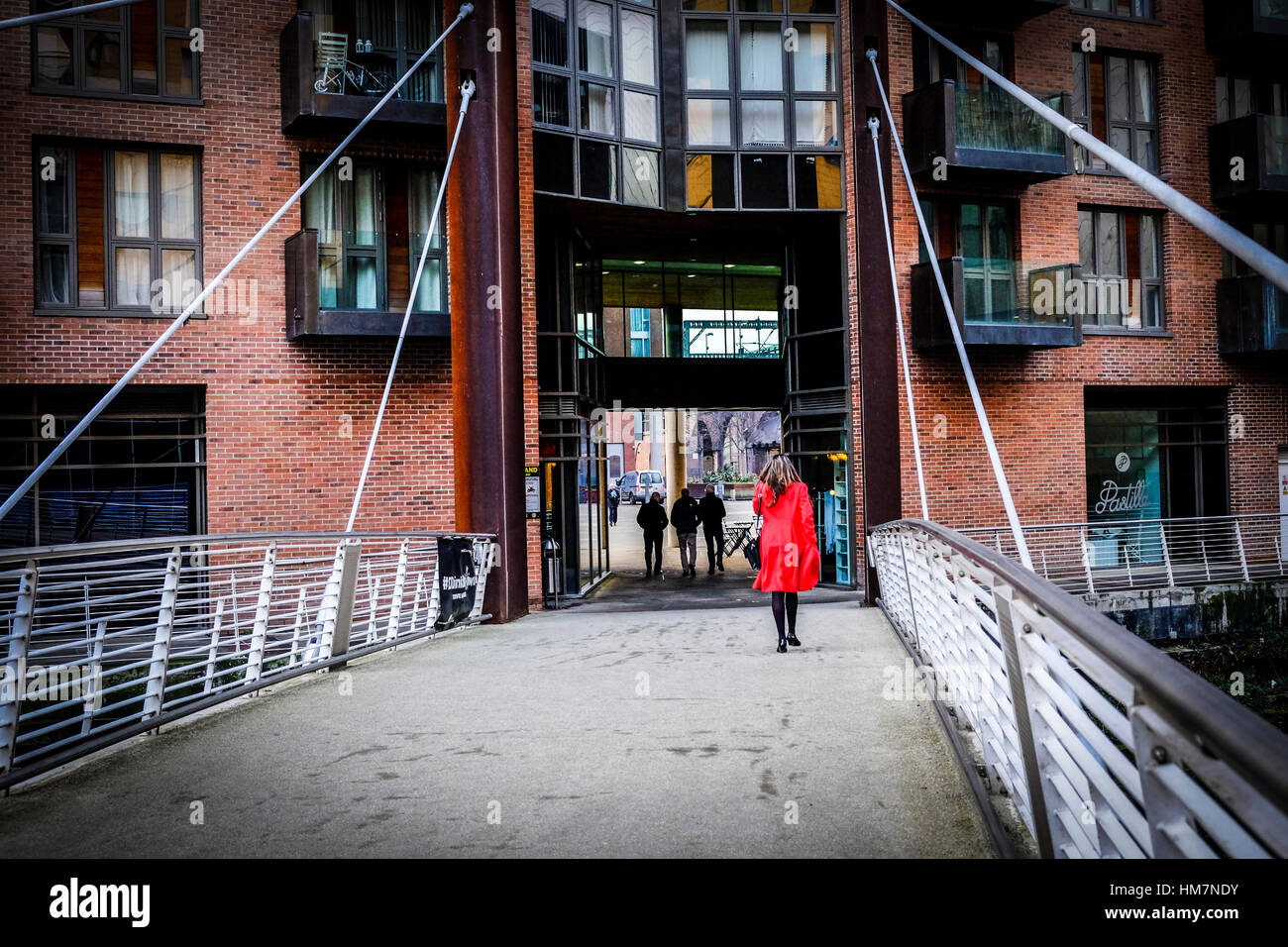 A piedi femmina per lavorare in The Granary Wharf area di Leeds, West Yorkshire. Foto Stock