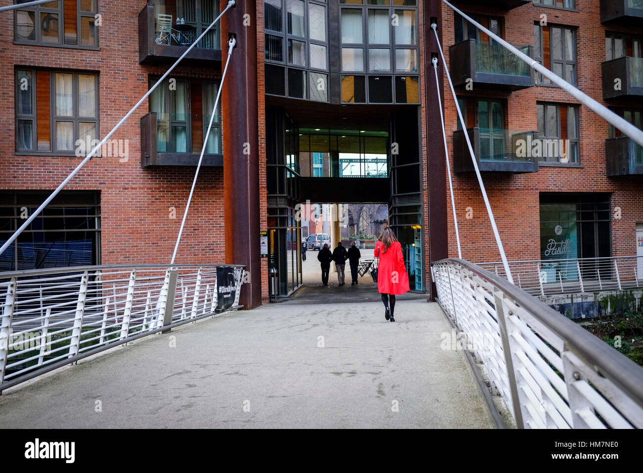 A piedi femmina per lavorare in The Granary Wharf area di Leeds, West Yorkshire. Foto Stock