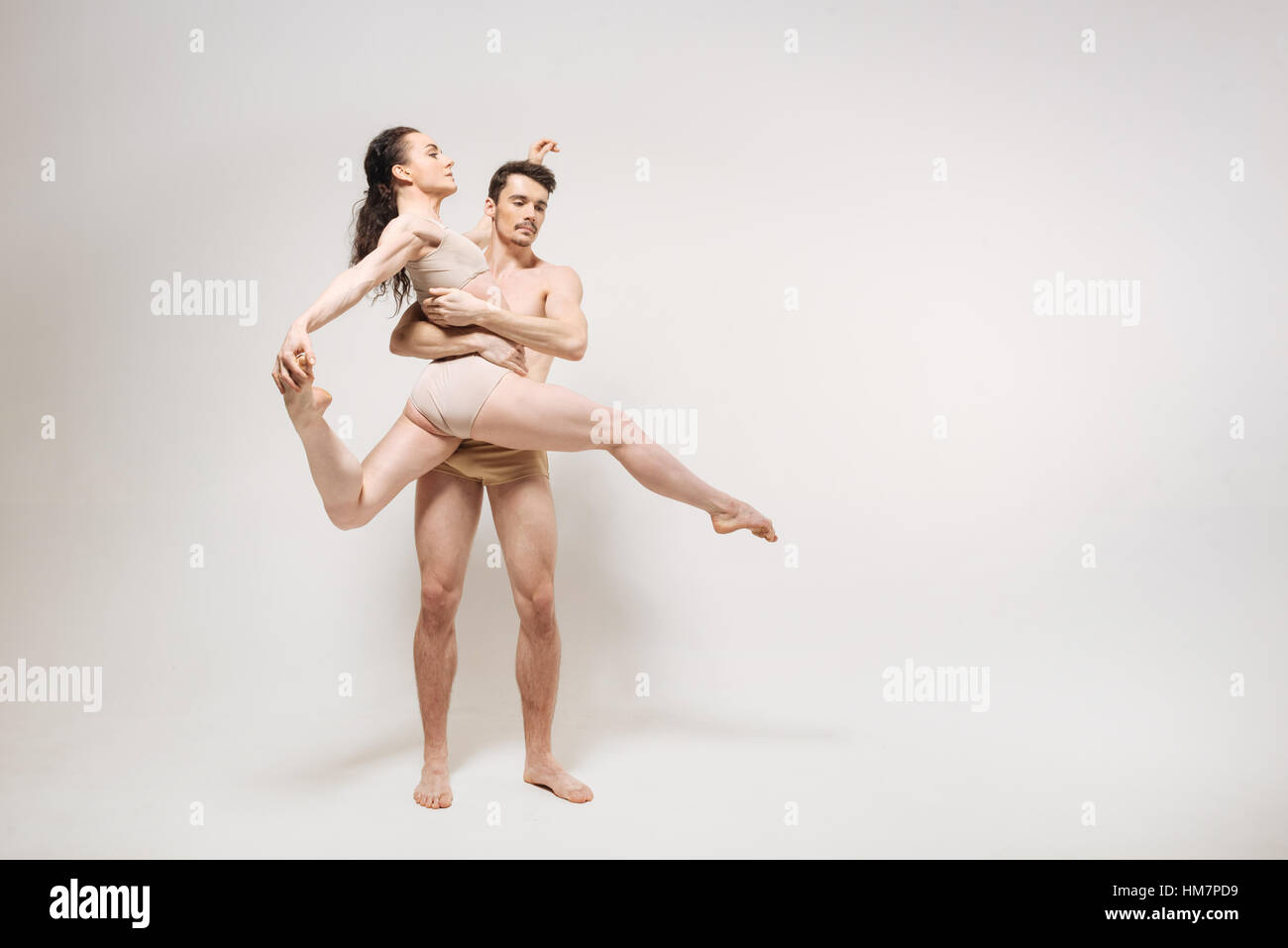 Proficient giovani ballerini eseguono in camera bianca Foto Stock