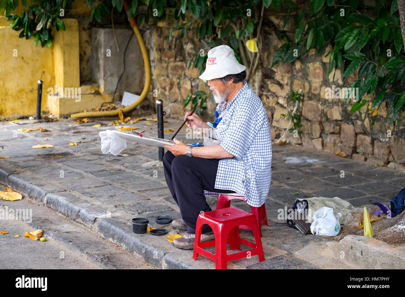 Uomo vecchio disegno in strada di Hoi An. Hoian è riconosciuta come patrimonio mondiale dall'UNESCO. HOIAN, Vietnam, gennaio 26 Foto Stock
