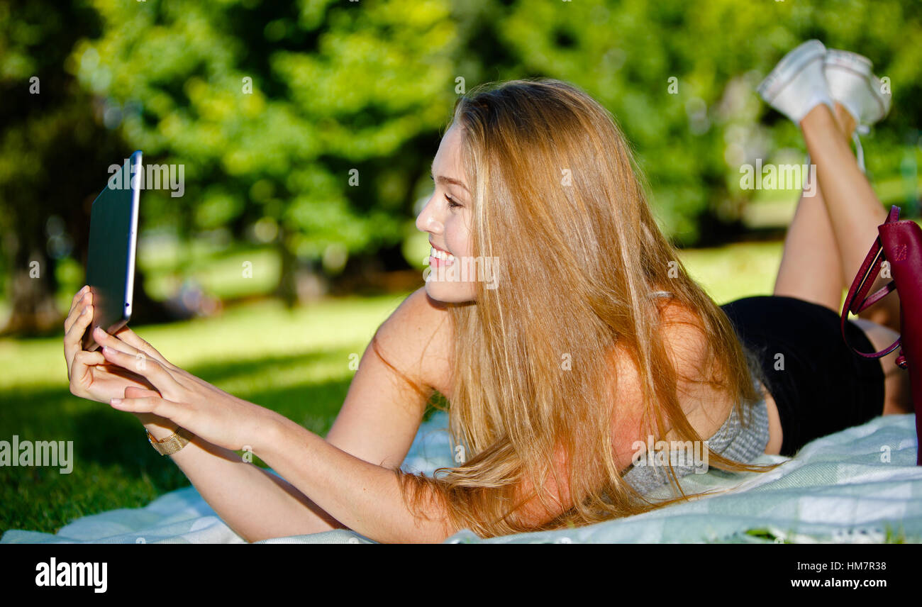 Felice ragazza è tenuto selfie con tavoletta all'aperto Foto Stock