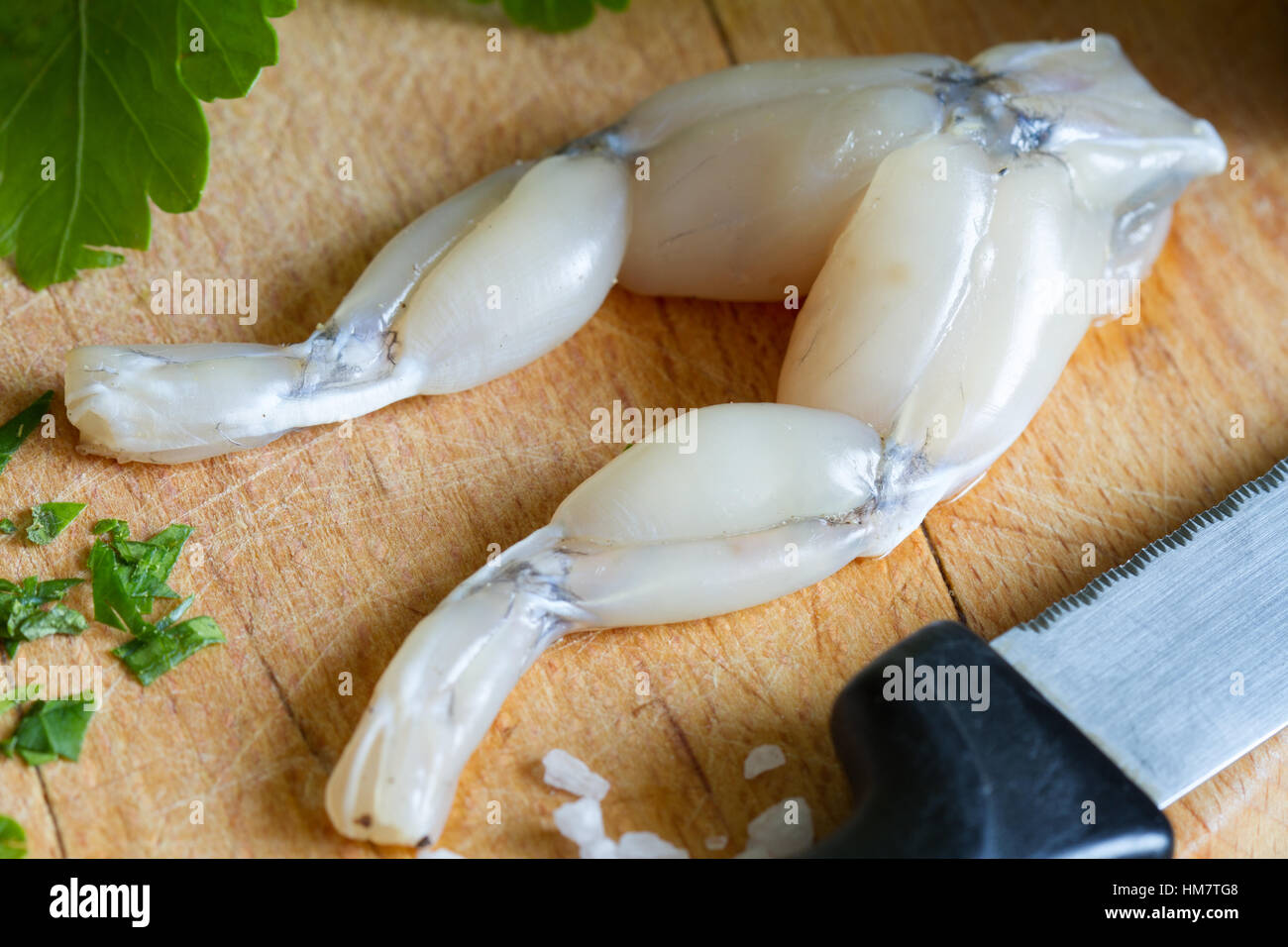 Materie di cosce di rana sul tagliere in cucina closeup Foto Stock