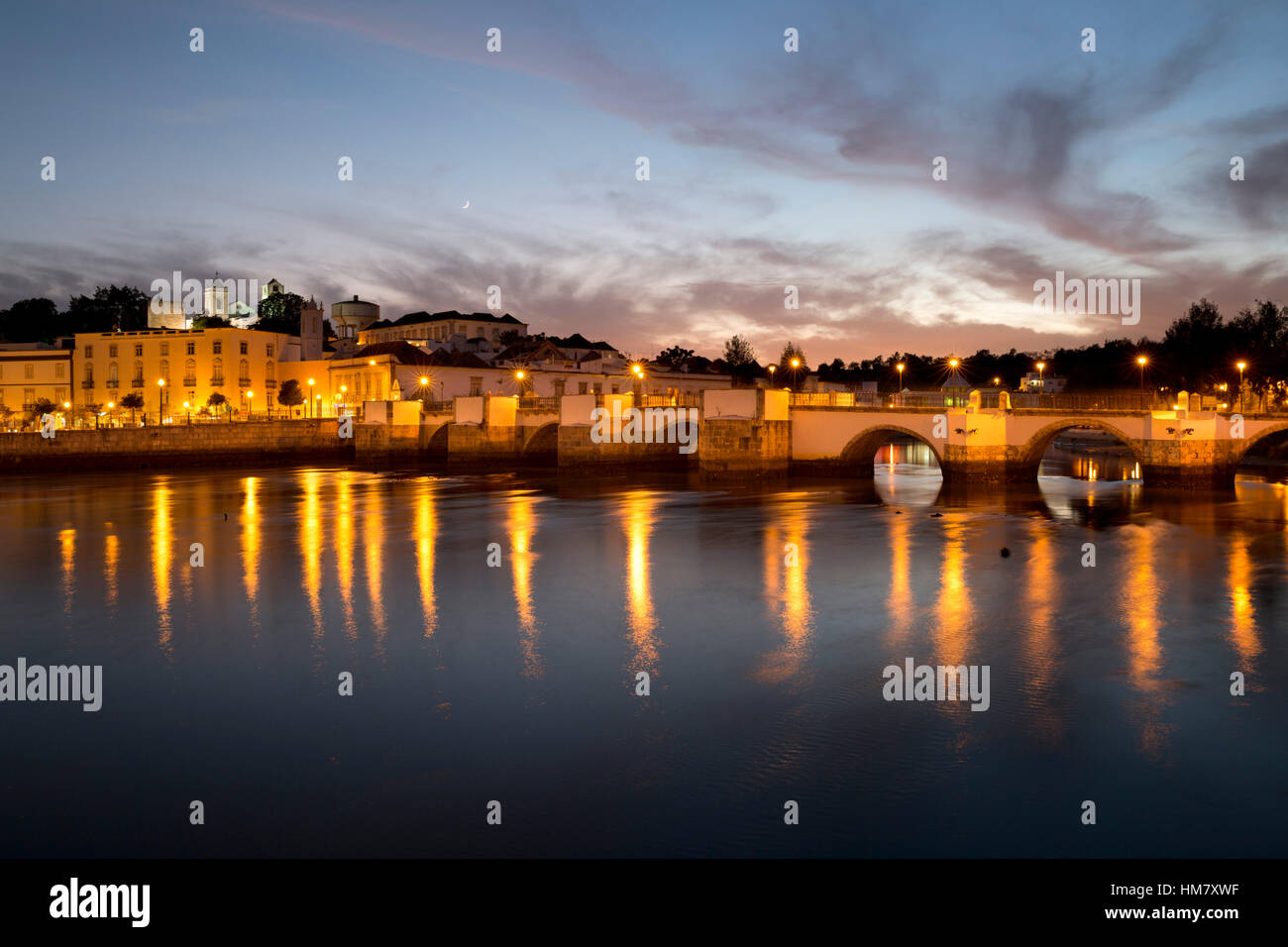 Sette arcate del ponte romano e la città sul Rio fiume Gilao di notte, Tavira, Algarve, Portogallo, Europa Foto Stock