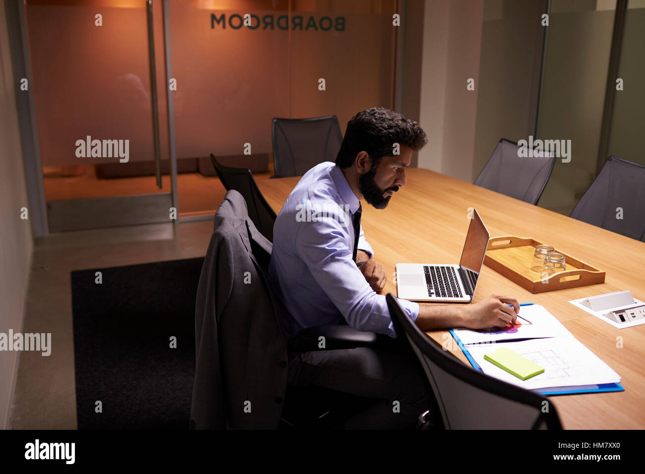 Imprenditore ispanica lavora fino a tardi in ufficio, vista in elevazione Foto Stock