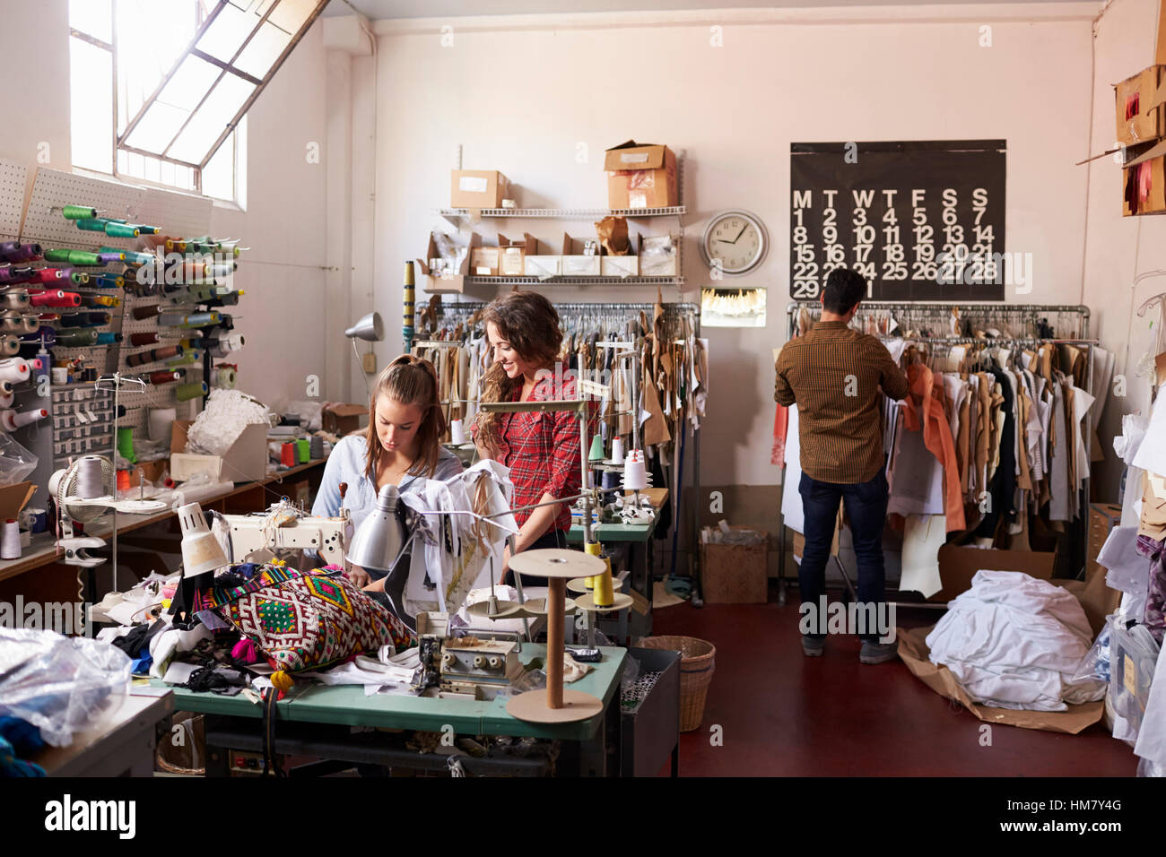 I colleghi che lavora in una vestiti design studio a piena lunghezza Foto Stock