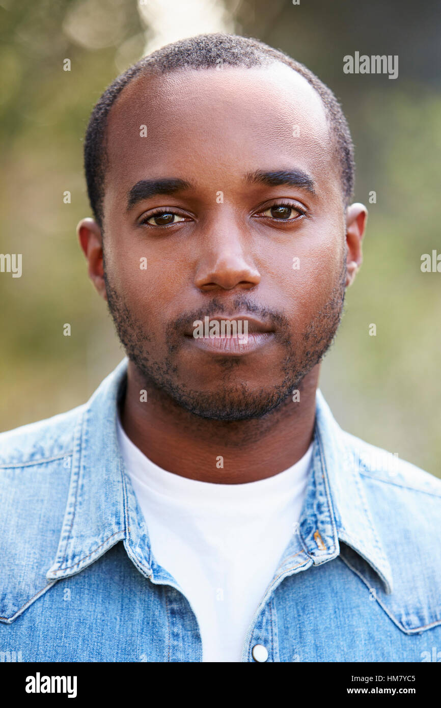 Giovane americano africano Uomo in camicia denim, ritratto verticale Foto Stock