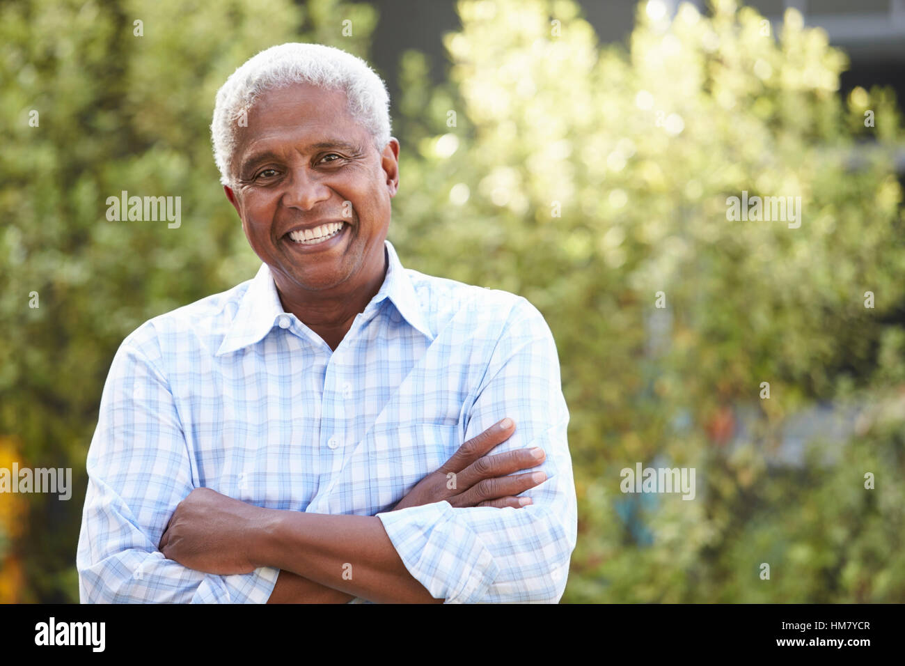 Sorridente senior African American uomo con le braccia incrociate Foto Stock