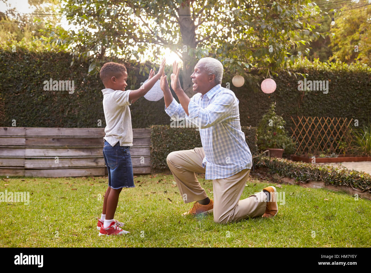 Nonno nero gioca con il nipote in giardino a piena lunghezza Foto Stock