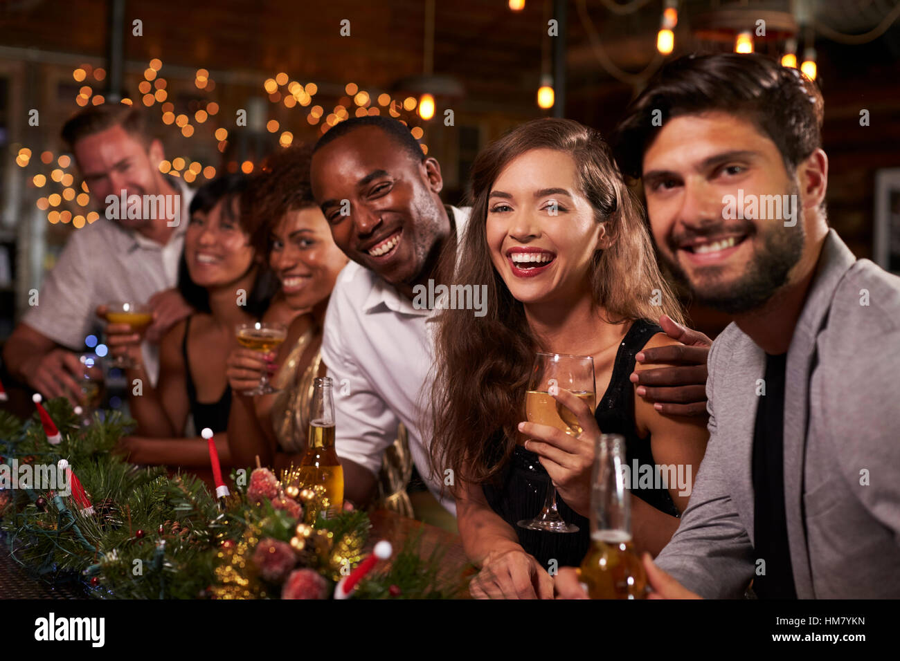 Amici godendo le celebrazioni del Natale guardare alla fotocamera Foto Stock
