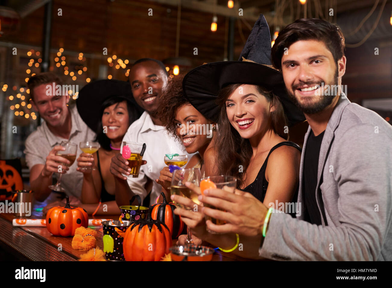 Amici godendo di una festa di Halloween presso un bar guardano alla fotocamera Foto Stock