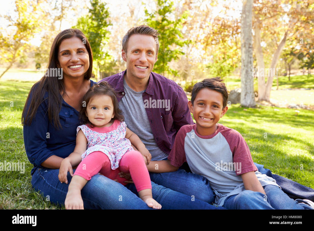 Felice Asian Caucasian razza mista famiglia, ritratto in un parco Foto Stock