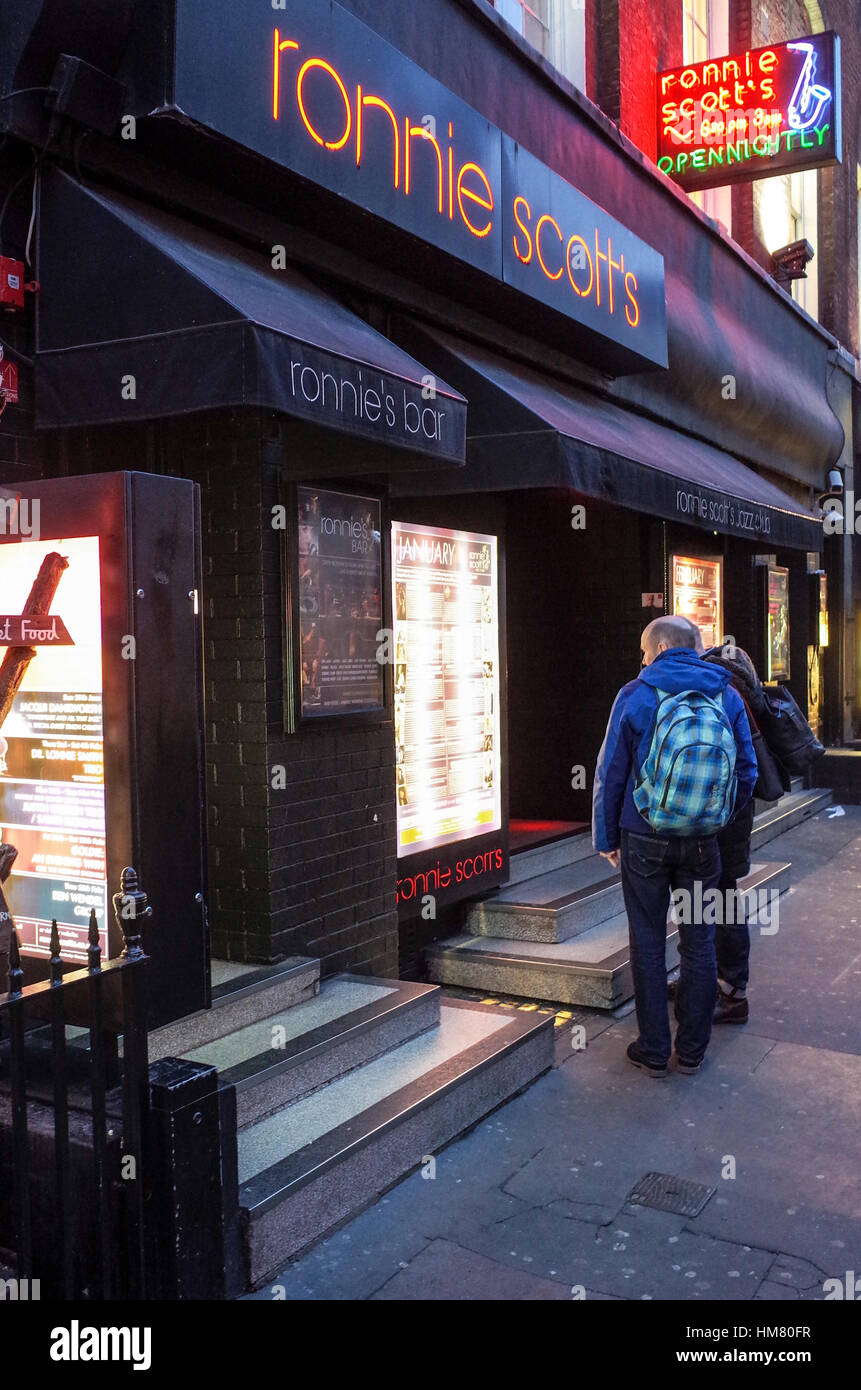 I turisti sfogliare gli elenchi al di fuori di Ronnie Scott's jazz club di Londra area Soho Foto Stock