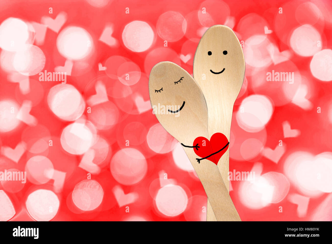 Coppia felice abbraccio concetto, sorridente dipinta su cucchiai, il giorno di san valentino sfondo Foto Stock