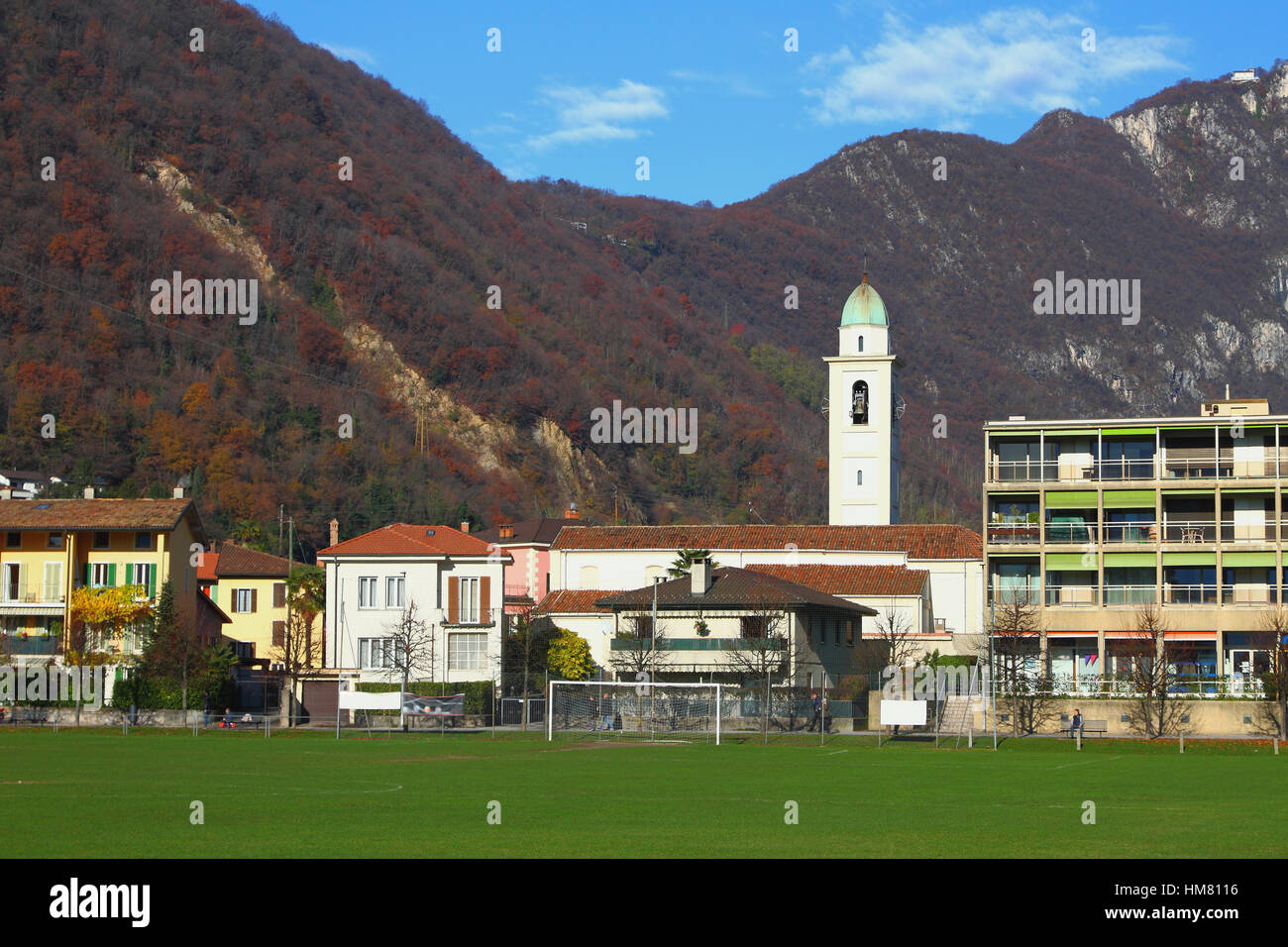 Città e chiesa nelle Alpi. Melide, Svizzera Foto Stock