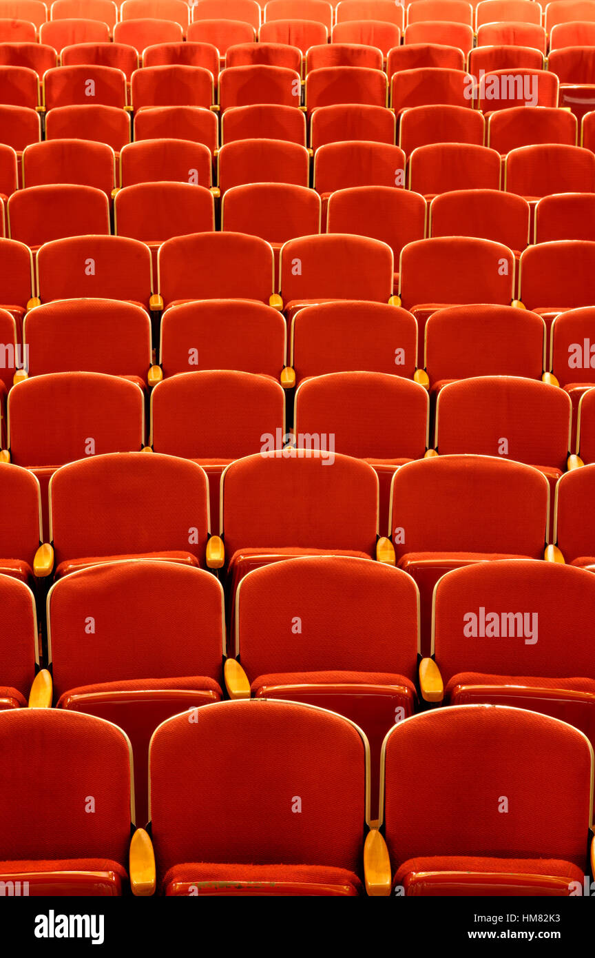 Teatro vuoto sedi in rosso vivo con braccio di legno appoggia, di una sala da concerto di vista dello stadio di nessun pubblico o patroni, vecchio stile di posti a sedere Foto Stock