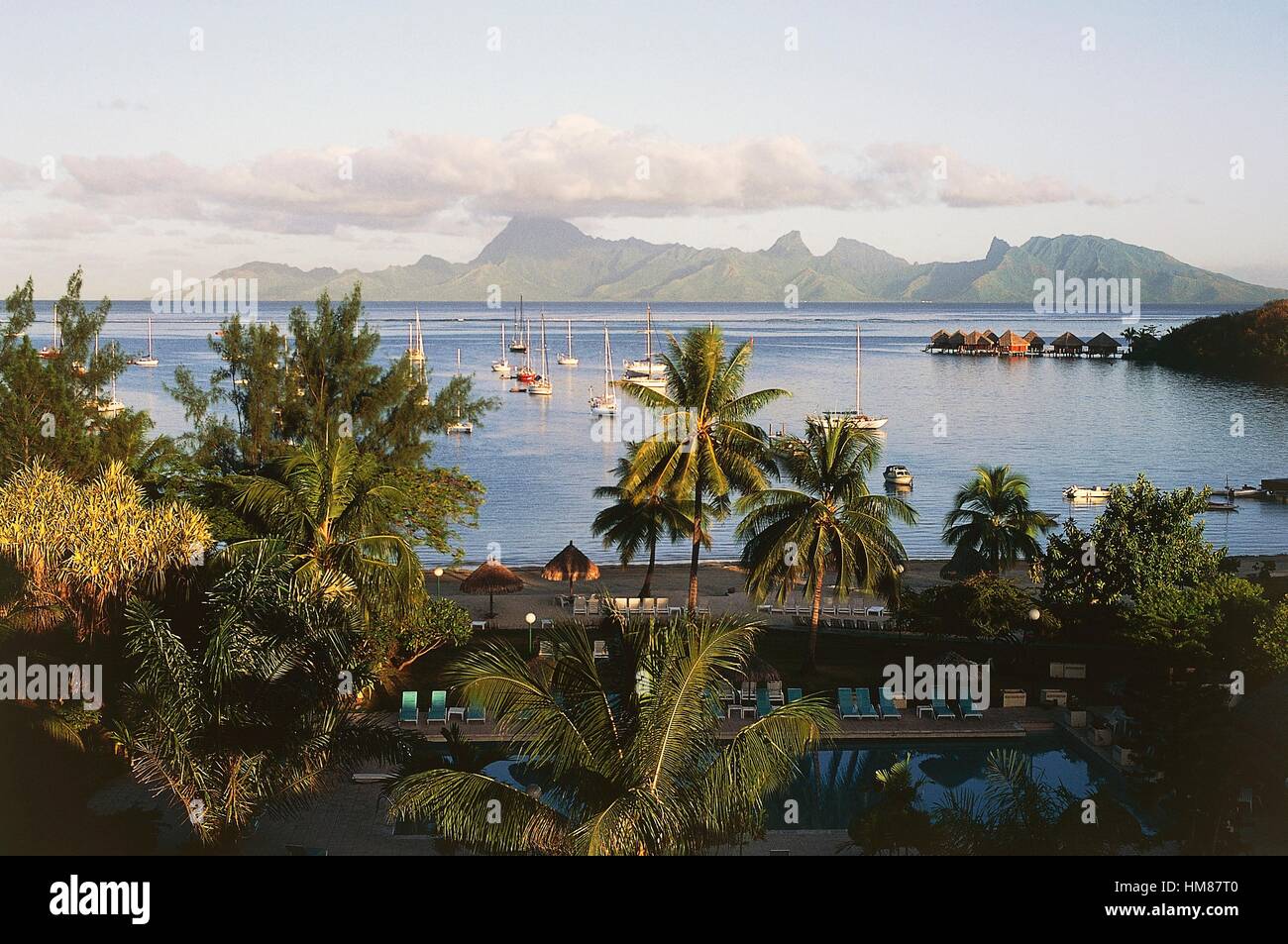 Vista dell'isola di Tahiti con barche ormeggiate e stazioni palafitticole, isole della Società, Polinesia francese. Foto Stock