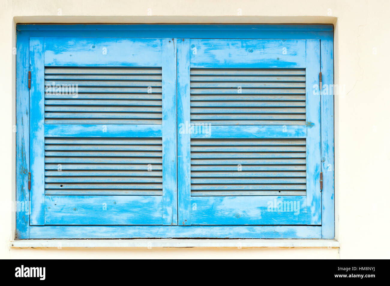 Blue persiane in legno con fori di ventilazione in bianco muro di pietra. Resort di classica architettura Greca, bianco-blu di costruzione di casa sulla riva del mare cretese. Ri Foto Stock