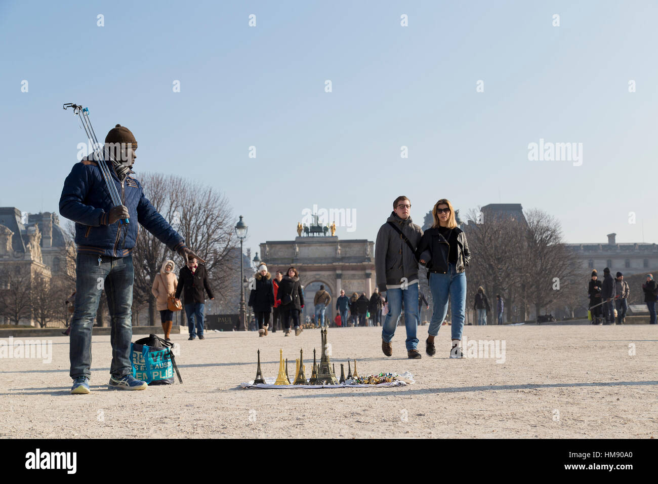 Migranti africani che vendono souvenir e bastoni selfie nei giardini delle Tuileries a Parigi in inverno Foto Stock