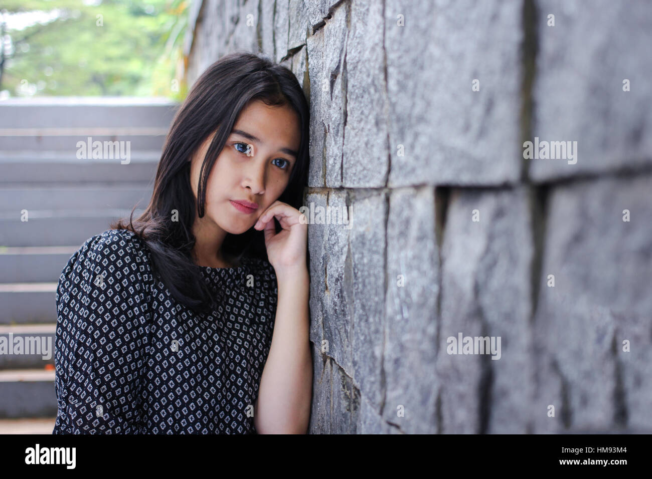 Ragazza in posa vicino alla parete Foto Stock