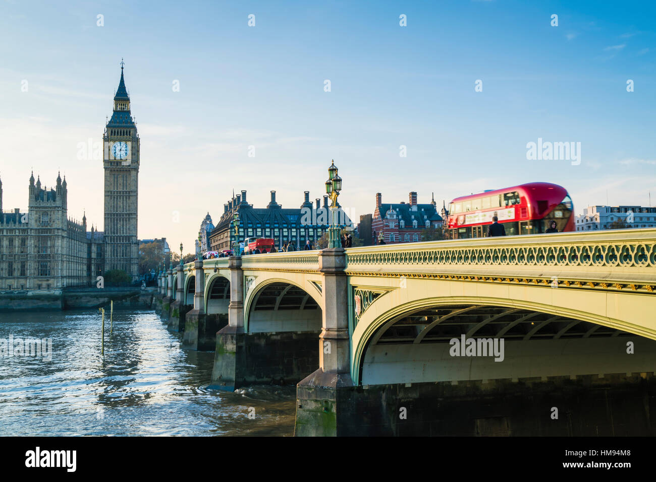 Bus rosso crossing Westminster Bridge verso il Big Ben e le Camere del Parlamento, London, England, Regno Unito Foto Stock