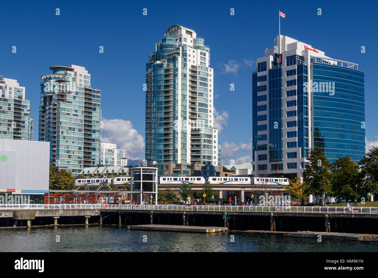Il Quayside edifici ad alta e lo Skytrain sul bordo di False Creek presso il Centro Scientifico Telus Park, Vancouver, British Columbia, Canada. Foto Stock