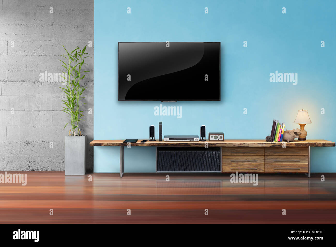 Tv su azzurro parete con tavolo in legno e piante in vaso soggiorno interrior Foto Stock