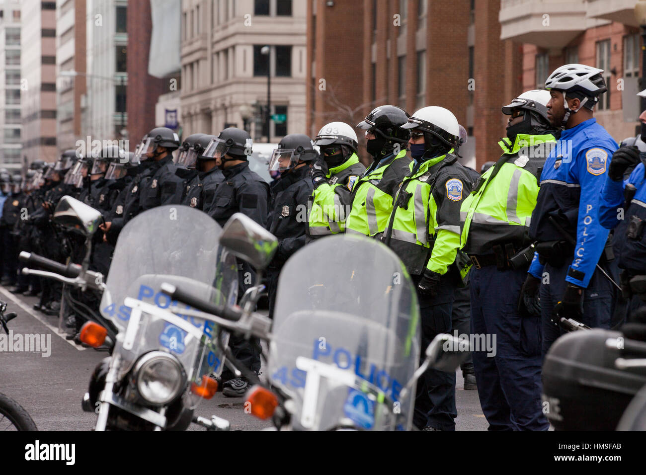 La Metropolitan Police in piedi in formazione contro i dimostranti durante 2017 inaugurazione presidenziale - Washington DC, Stati Uniti d'America Foto Stock