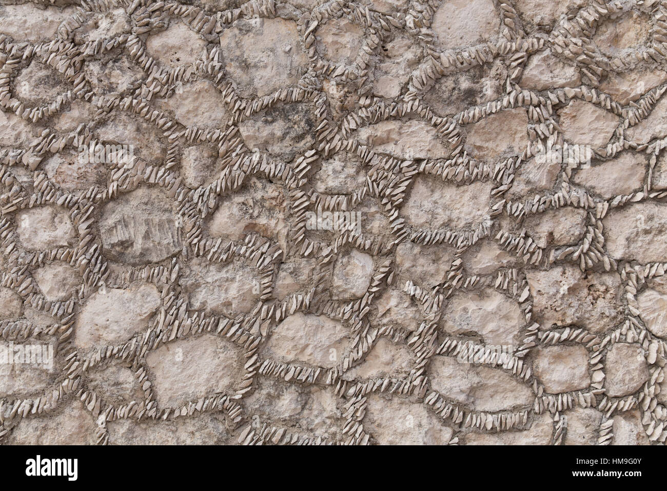 Un muro di pietra con piccoli sassi in mortaio. Foto Stock