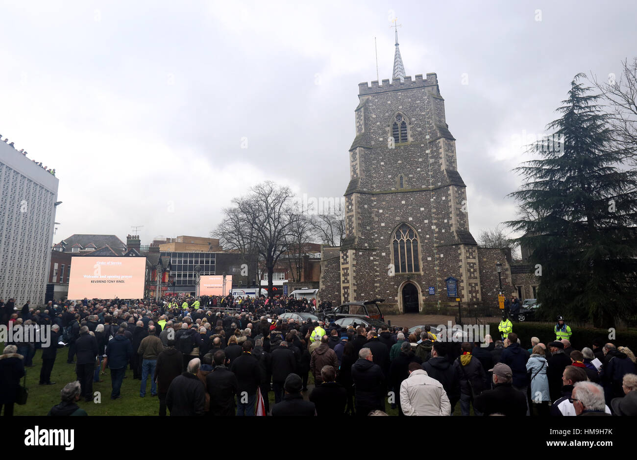 Le persone si raccolgono al di fuori della chiesa e per ascoltare le preghiere di apertura per il servizio funebre di Graham Taylor tenutosi presso la chiesa di Saint Mary, Watford. Foto Stock