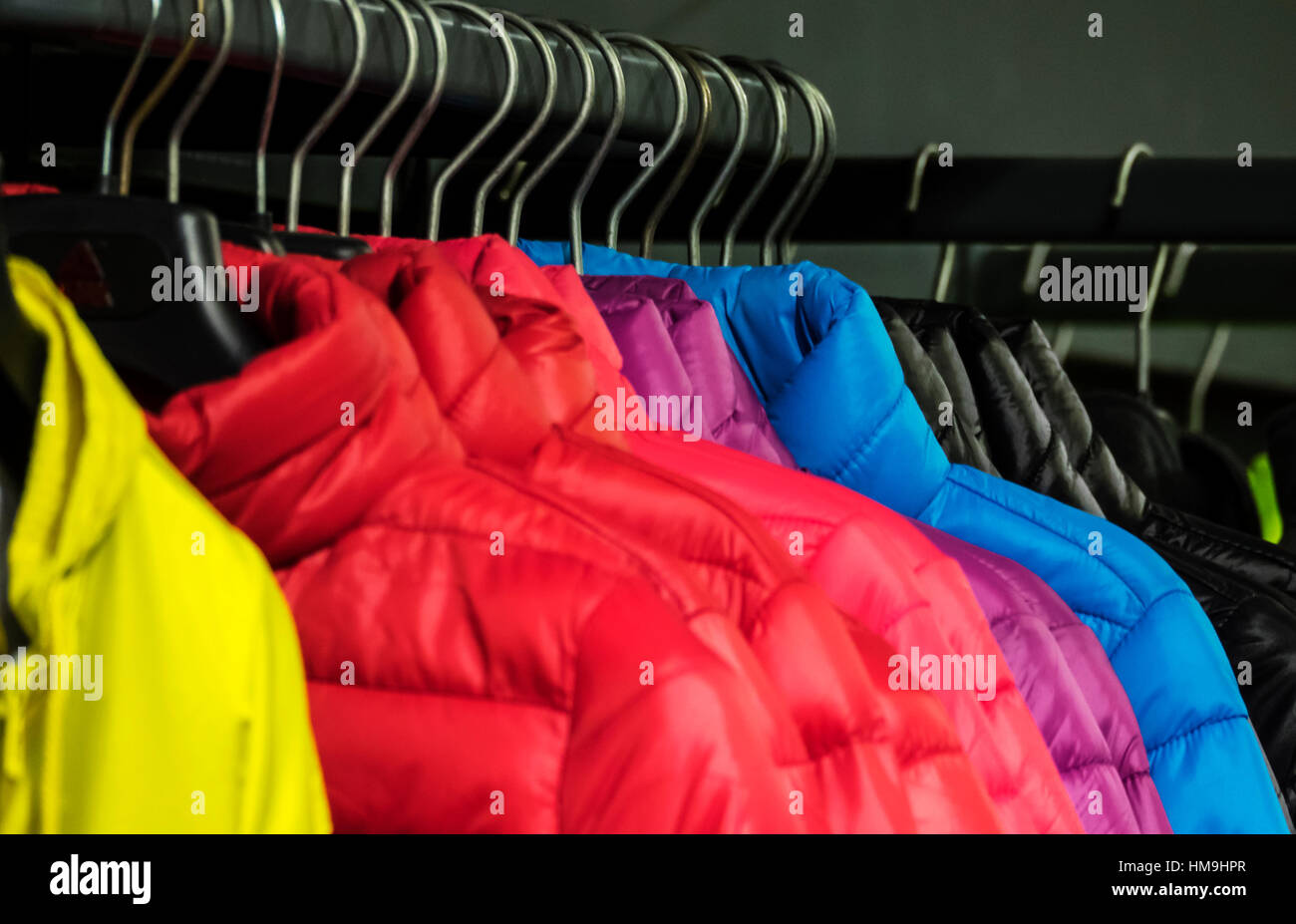 Colorata collezione di capi di abbigliamento femminile appeso su un rack Foto Stock
