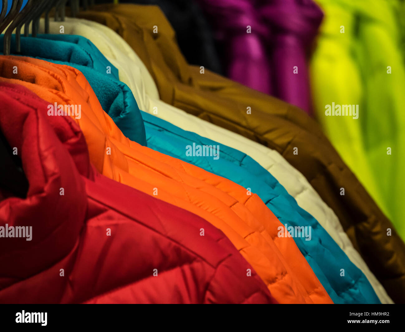 Colorata collezione di capi di abbigliamento femminile appeso su un rack Foto Stock