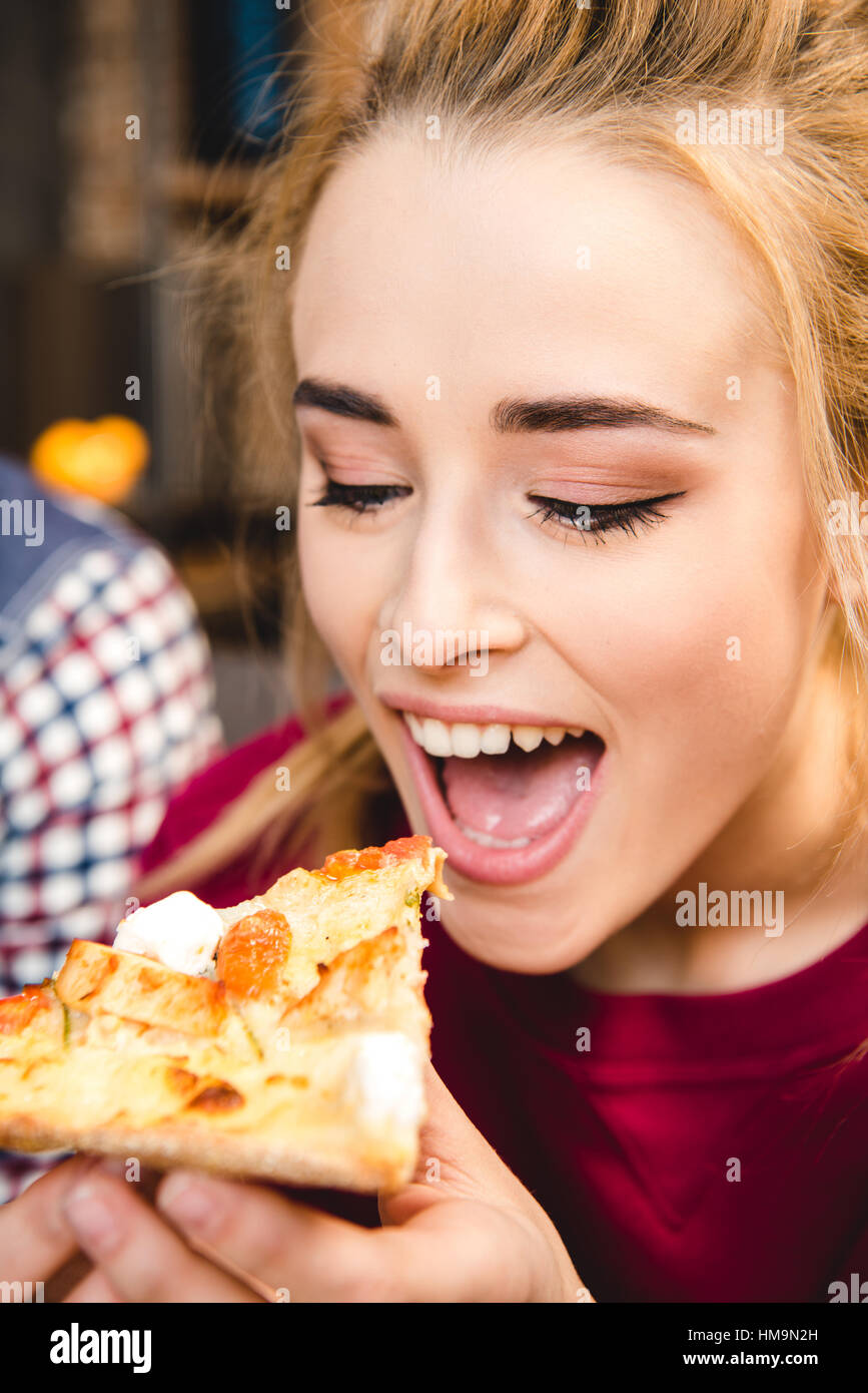 Donna di mangiare la pizza Foto Stock