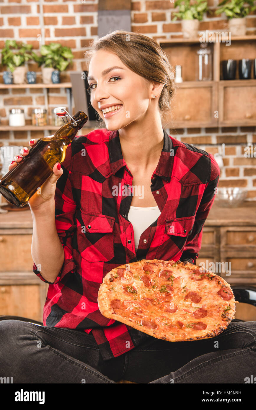 Donna con birra e pizza Foto Stock