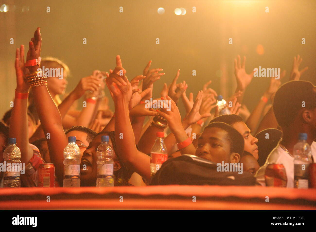 I giovani in un concerto con bracci sventolando in aria Foto Stock
