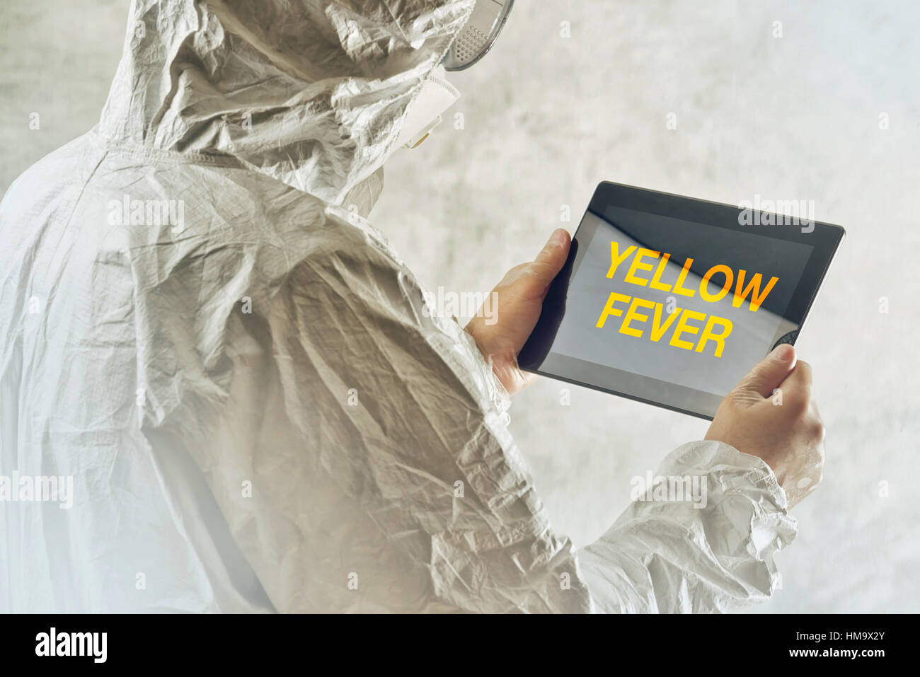 Scienziato medico utilizzando computer tablet per ottenere informato circa la febbre gialla malattia Foto Stock
