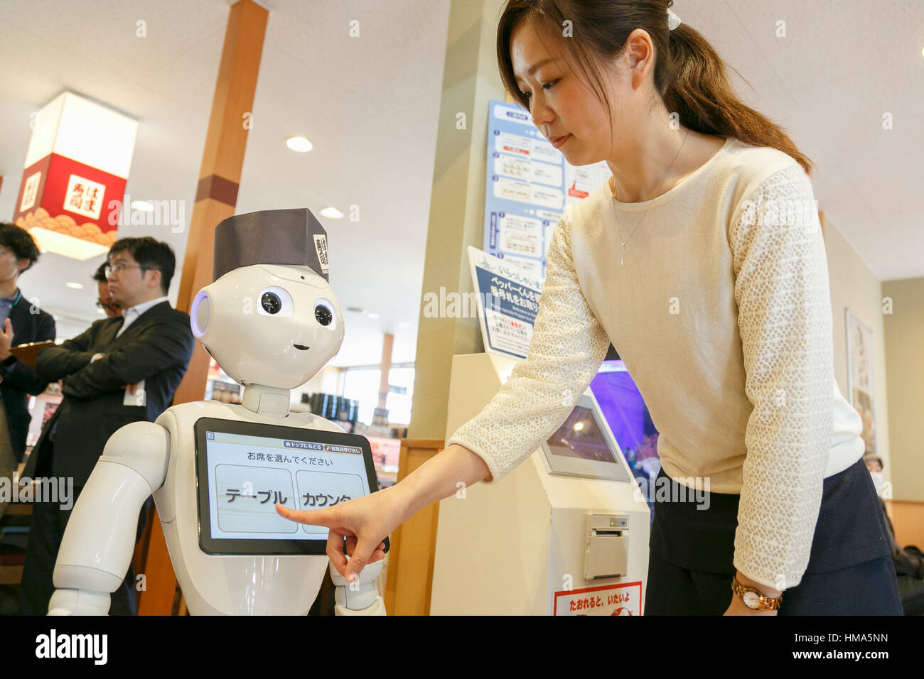 Tokyo, Giappone. 2° febbraio 2017. Un membro del personale dà una dimostrazione di pepe di robot come receptionist dell'Hamazushi nastro trasportatore ristorante di sushi in Saitama, appena a nord di Tokyo il 2 febbraio 2017, in Giappone. Il robot umanoide creato da SoftBank Robotics è in fase di collaudo da parte della catena di sushi di salutare, prendere tabella prenotazioni e lasciare che i clienti sappiano quando loro sedi sono pronti. Pepe è stata introdotta per migliorare la velocità di servizio al già altamente automatizzato di ristorante. Credito: Aflo Co. Ltd./Alamy Live News Foto Stock