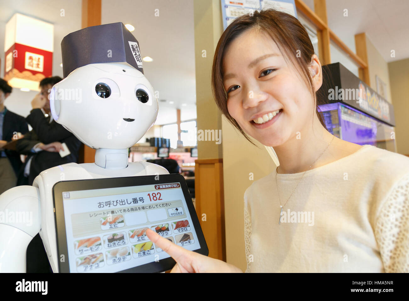 Tokyo, Giappone. 2° febbraio 2017. Un membro del personale dà una dimostrazione di pepe di robot come receptionist dell'Hamazushi nastro trasportatore ristorante di sushi in Saitama, appena a nord di Tokyo il 2 febbraio 2017, in Giappone. Il robot umanoide creato da SoftBank Robotics è in fase di collaudo da parte della catena di sushi di salutare, prendere tabella prenotazioni e lasciare che i clienti sappiano quando loro sedi sono pronti. Pepe è stata introdotta per migliorare la velocità di servizio al già altamente automatizzato di ristorante. Credito: Aflo Co. Ltd./Alamy Live News Foto Stock