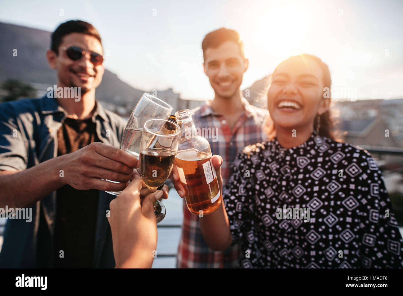 Giovani amici festeggiare insieme. Gruppo di persone come tostare il drink in un partito sul tetto. Foto Stock Giovani amici festeggiare insieme. Gruppo di persone come tostare il drink in un partito sul tetto. Foto Stock